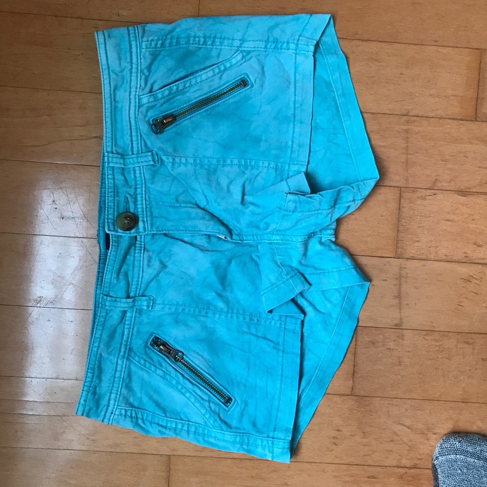 Teal shortie shorts with zippers on the pockets